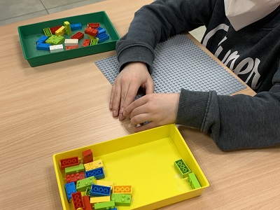 Niño jugando con piezas lego en braille