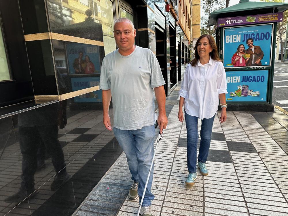 Estrella enseñando a Pedro Manuel el uso del bastón durante un paseo por la calle