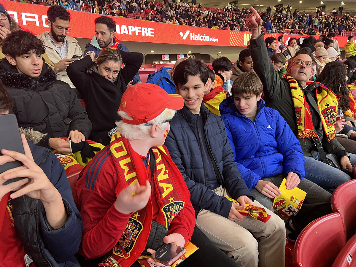 Niños con discapacidad visual y sin ella en la grada de un Estadio de Fútbol con banderas de España