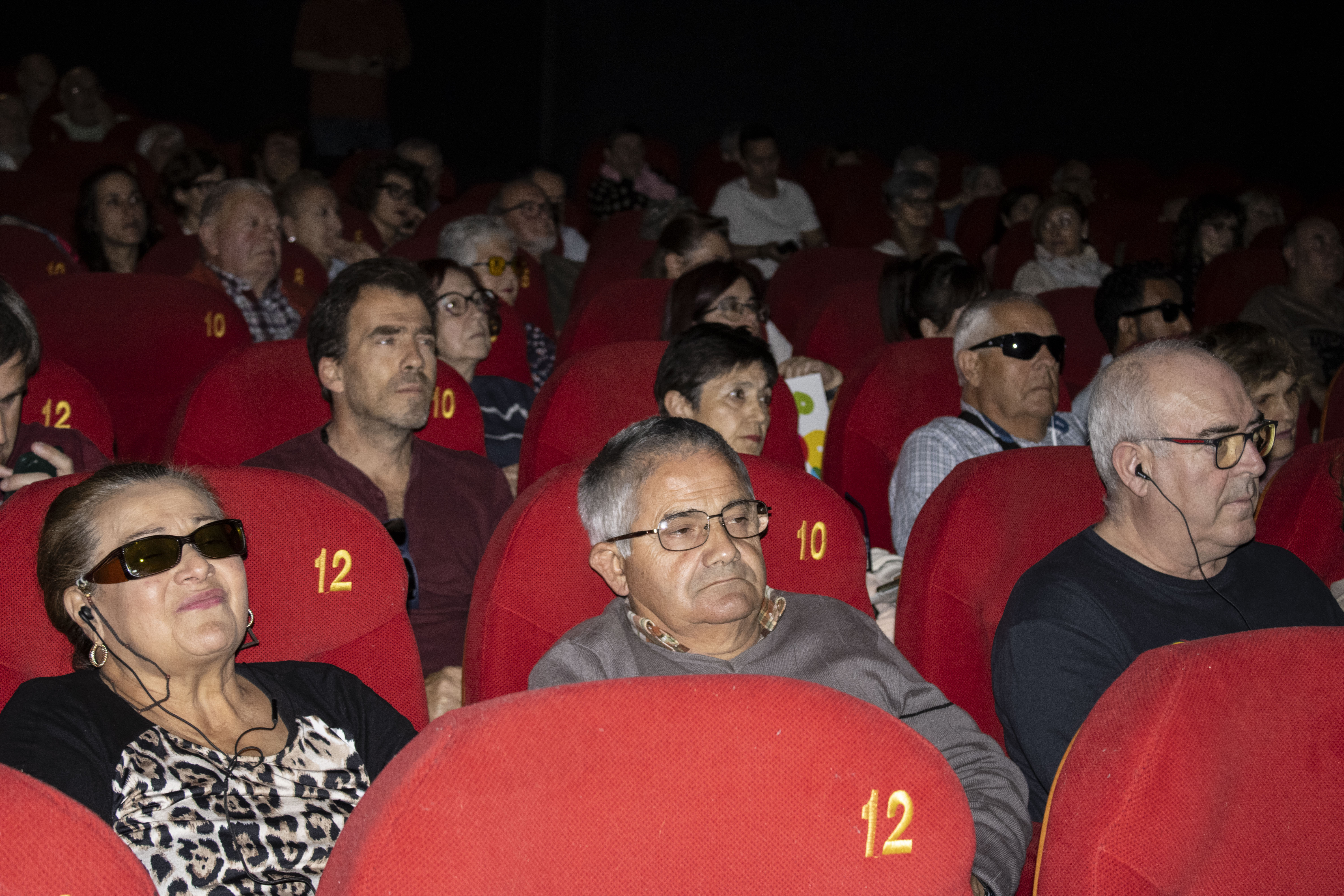 Personas ciegas en la sala del cine disfrutando de las películas con a audiodescripción
