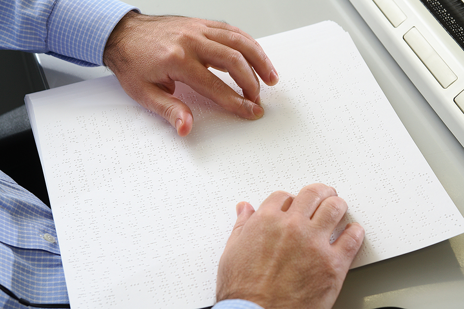 Detalle de unas manos tocando braille