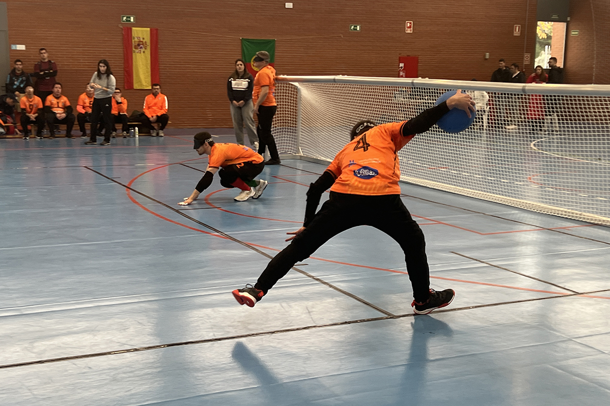 Un equipo de goalball en un partido. Se ve como uno de los jugadores está lanzando el balón