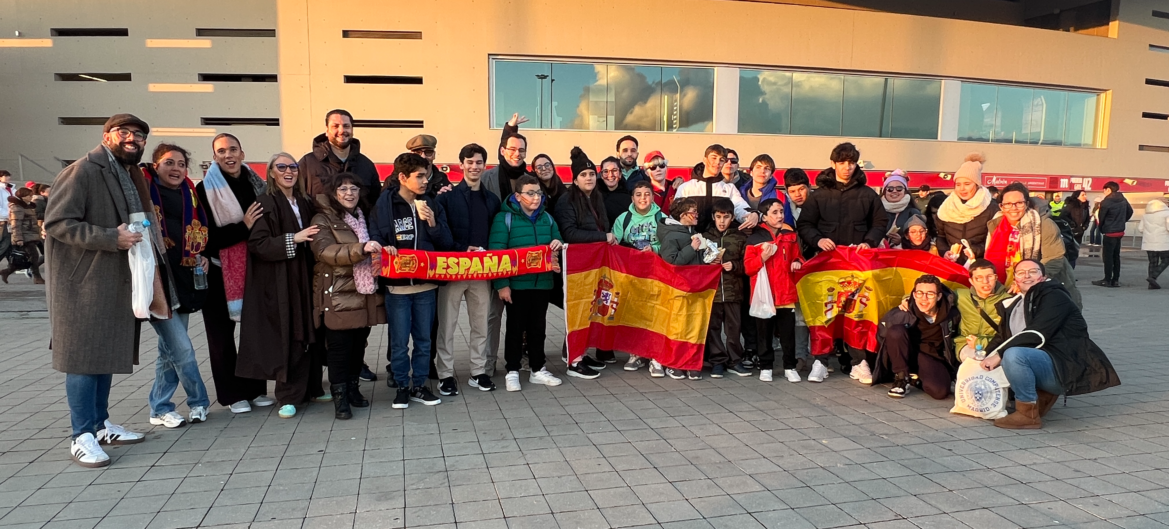Grupo de alumnos y equipo de atención educativo del CRE de Madrid en las puertas del Estadio Metropolitano antes del partido con banderas de España
